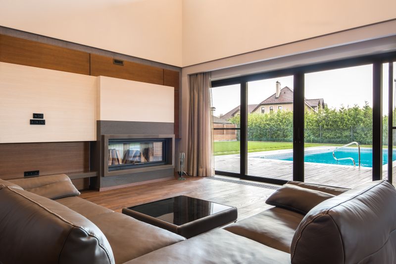 Spacious modern living room with glass doors opening to a poolside area